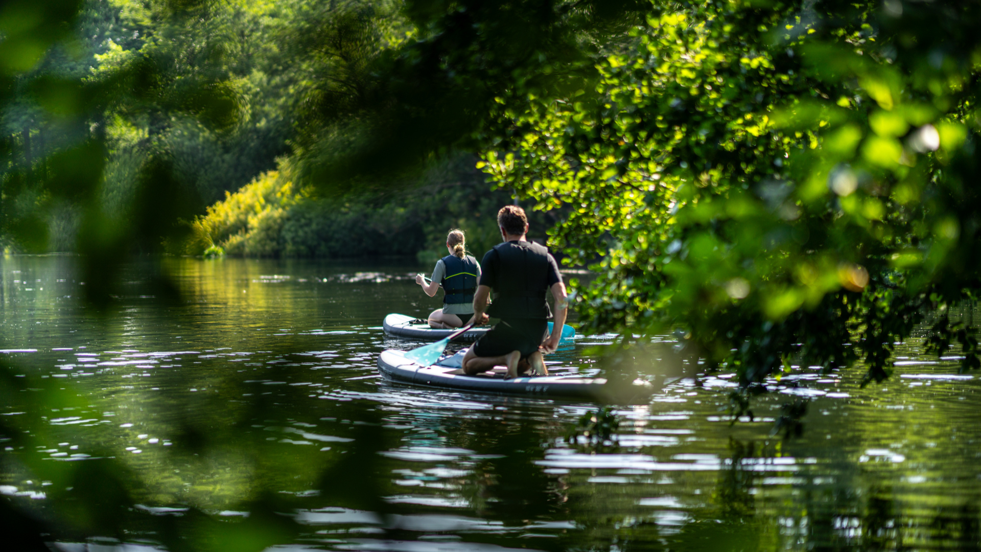 To unge der paddleboarder på vand